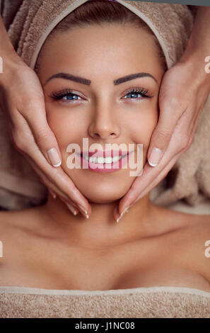 Spa donna, close-up di una giovane donna di ottenere il trattamento termale e massaggio del viso Foto Stock