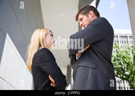 Due business caucasica persone fissando ogni altro rabbiosamente Foto Stock