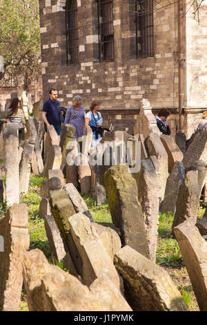 La gente camminare tra le lapidi del vecchio cimitero ebraico presso la sinagoga di Pinkas Praga Foto Stock