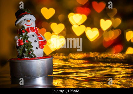 Pupazzo di neve di Natale a forma di cuore le luci in background, a forma di cuore di sfocatura bokeh di fondo Foto Stock