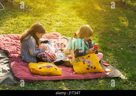 Due bambine avente picnic nel giardino di casa Foto Stock