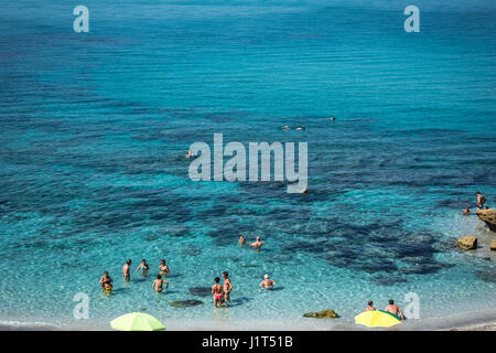 Alcune persone e ombrelloni nel mare turchese in una giornata di sole a San Giovanni di Sinis costa, Cabras, provincia di Oristano, Sardegna, Italia. Foto Stock