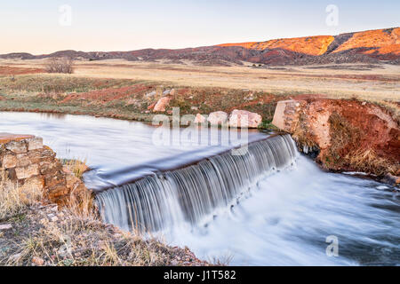 Una piccola diga in Colorado settentrionale pedemontana - Parco Creek è in esecuzione l'acqua deviata dalla forcella del nord del fiume Poudre per riempire un serbatoio downstre Foto Stock