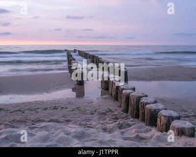 I frangiflutti in legno su una spiaggia del Mar Baltico Foto Stock