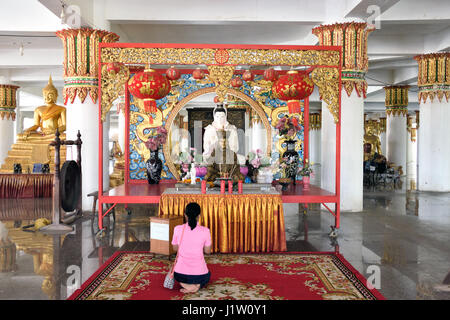 Un piccolo santuario cinese nella sala sotto il grande elefante rosa in Wat Phrong Akat in Bang Nam Priao quartiere centrale di Thailandia Foto Stock