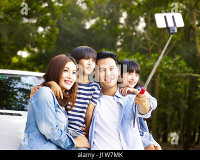 Famiglia asiatica con due bambini prendendo un selfie durante un viaggio. Foto Stock