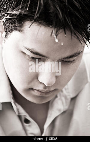 Un bianco e nero girato di un depresso giovane maschio asiatici (SHALLOW DOF, concentrarsi su gli occhi) Foto Stock