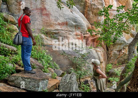 Turistiche e guide alla ricerca sull'arte rupestre, antica San dipinti, Tsodilo Hills, Botswana, Africa Foto Stock