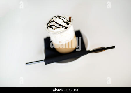 Caffè lungo con crema e cioccolata calda sul tavolo Foto Stock