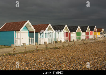 Pittoresca spiaggia di capanne sul lungomare a Lancing, West Sussex, in Inghilterra. Con molto buia e tempestosa sky Foto Stock