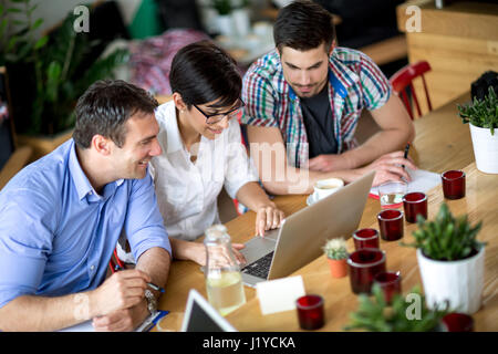 Tre persone che lavorano sul negozio laptop nel caffè Foto Stock