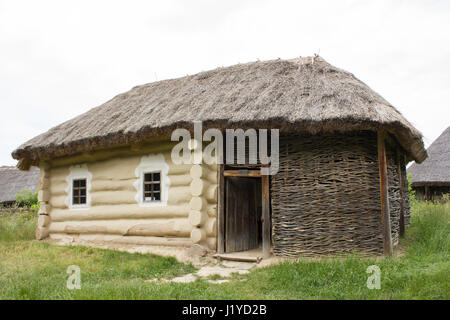 Una vecchia casa in legno con tetto di paglia Foto Stock