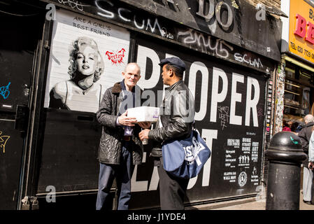 Street photography in Brick Lane con il vecchio uomo accanto a un graffiti raffiguranti Marilyn Monroe. Brick Lane, Shoreditch, London, Regno Unito Foto Stock