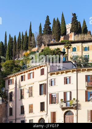 Viaggiare in Italia - case urbane sulla strada Via Festa del Redentore e la collina con Castel San Pietro nella città di Verona in primavera Foto Stock