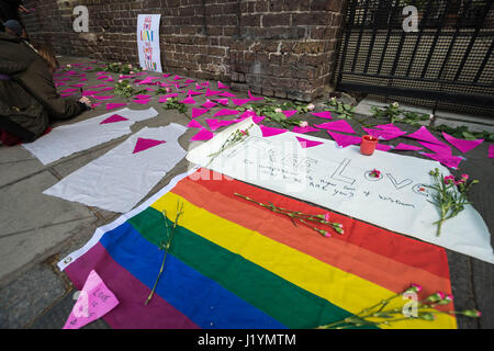 Londra, Regno Unito. Il 22 aprile, 2017. Gli attivisti continuano le proteste al di fuori dell'Ambasciata russa a Londra contro riportato "purghe" di uomini gay e di violazioni dei diritti umani in Cecenia. Gli attivisti LGBT luogo messaggi di sostegno scritto su rosa carta triangolare di fronte all'ambasciata cancelli e parete. © Guy Corbishley/Alamy Live News Foto Stock