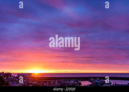 Inghilterra, Ramsgate porto. Alba sul canale Inglese. In primo piano il Porto di Ramsgate. Piccola banda di aprire il cielo arancione con il sorgere del sole, al di sopra di quello spessore stratificato cloud malva. Foto Stock