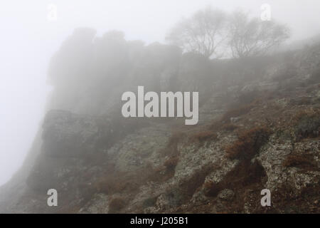 Misterioso paesaggio con una vista delle montagne della Crimea coperta di nebbia Foto Stock