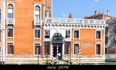 Venezia, Italia - 30 Marzo 2017: l'uomo sul molo vicino palazzo sul Canal Grande a Venezia. Il Grand Canal costituisce uno dei principali acqua corridoi di traffico in t Foto Stock