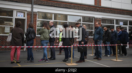 Cittadini francesi nella coda di voto ai seggi al Lycee Francais Charles de Gaulle in Kensington, London, come voto si apre in uno dei più angusto elezioni presidenziali francesi nelle generazioni. Foto Stock