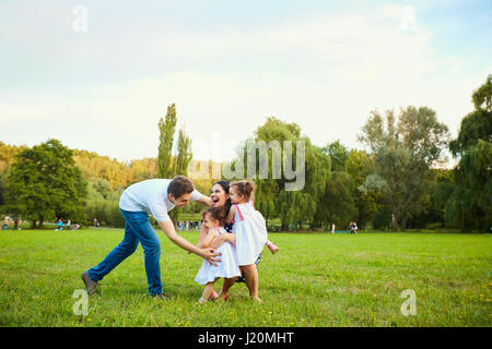 La famiglia felice a giocare con i bambini nel parco. Foto Stock