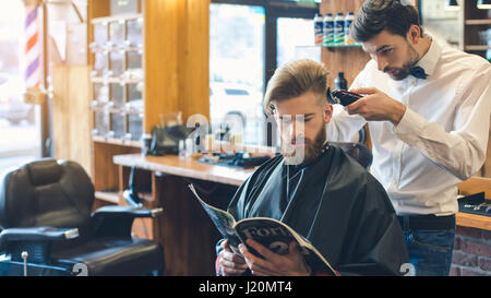 Giovane uomo in Barberia per la cura dei capelli il concetto di servizio Foto Stock