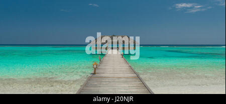 Pontile in legno sul bellissimo mare maldiviano Foto Stock