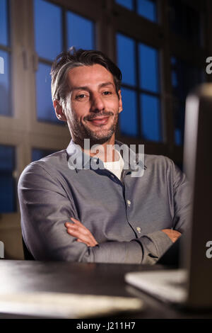 Uomo al lavoro in ritardo in ufficio Foto Stock