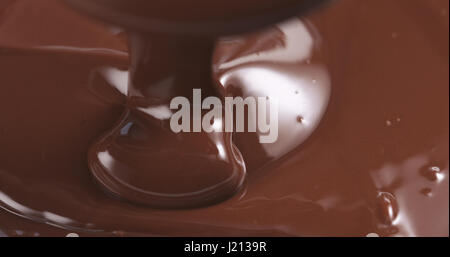 Movimento lento del premio dark cioccolato fuso che viene colato dal cucchiaio nella parte sinistra del telaio, 4k foto Foto Stock