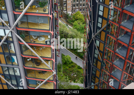 Un uomo cammina lungo un percorso tra due edifici di appartamenti nel centro di London REGNO UNITO Foto Stock