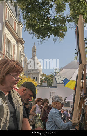 Pittore schizzi di Montmartre con il Sacro Cuore in background. Foto Stock