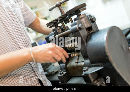 Goldsmith creazione di metallo con l'aiuto di una pressa Foto Stock