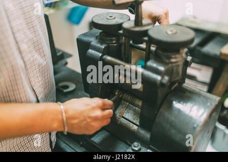 Goldsmith creazione di metallo con l'aiuto di una pressa Foto Stock