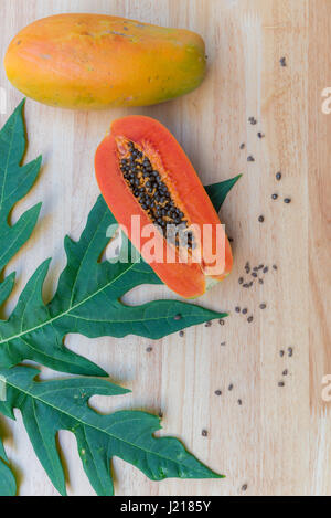 Papaia fresca frutta sul tavolo di legno con foglia verde Foto Stock