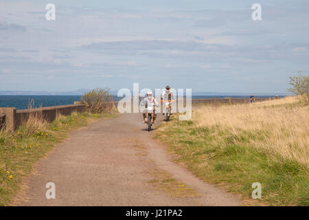 Edimburgo, Scozia, Regno Unito. 23 apr, 2017. Bike Rider a cavallo su un sentiero pedonale tra Musselburgh e Prestonpans nei pressi di Edimburgo, Scozia, Regno Unito. Meteo: 23 Aprile 2017 coperto con le magie di sole. Asciugare bellissime giornate di sole sulla costa di Edimburgo. Credito: Gabriela Antosova/Alamy Live News Foto Stock