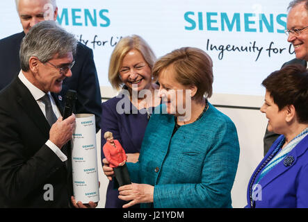 Hannover, Germania. 24 apr, 2017. Il cancelliere tedesco Angela Merkel (anteriore C) mantiene una scultura di se stessa fatta da 3D la stampa presso lo stand di Siemens durante la Hannover Messe 2017 di Hannover, Germania, 24 aprile 2017. La Hannover Messe 2017, con il tema "Industria integrata -- Creazione di valore' e la Polonia come il partner ufficiale di paese, durerà fino al mese di aprile 28. Credito: Shan Yuqi/Xinhua/Alamy Live News Foto Stock