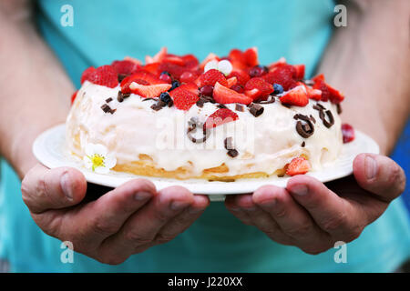 Torta in mani dell'uomo Foto Stock