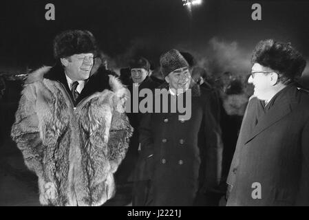 Il presidente statunitense Gerald Ford indossando un russo cappello di pelliccia e wolfskin umettare le chat con sovietica Segretario generale Leonid Brezhnev, del centro e del Segretario di Stato Henry Kissinger a Vozdvizhenka Airbase prima della partenza Novembre 24, 1974 a Vladivostok, Russia, URSS. Ford è in partenza a conclusione di una due giorni del Vertice sul controllo delle armi. Foto Stock