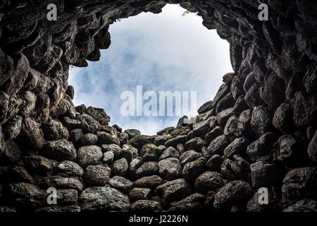 Nuraghe tipico interno con tettuccio di apertura per permettere alla luce di essa. Siti nuragici sono resti archeologici di epoca preistorica edificio di età del bronzo. Foto Stock