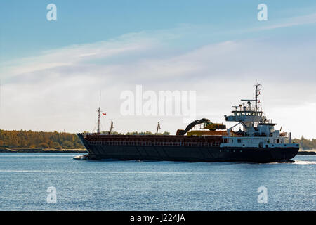 Nero nave cargo con long reach escavatore muovendo dal Mar Baltico Foto Stock