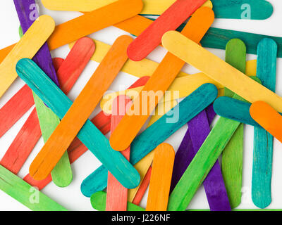 Disorderd in legno colorato abbassalingua su sfondo bianco. Foto Stock