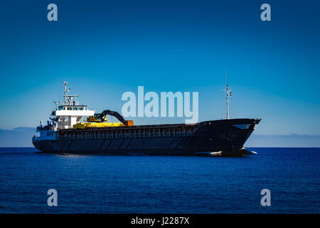 Nero nave cargo con long reach escavatore muovendo dal mar baltico Foto Stock