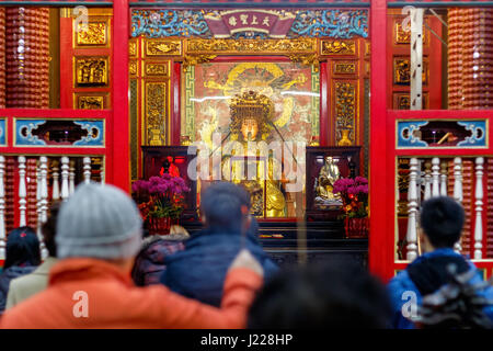 Mazu statua, un mare cinese dea, visto attraverso una folla di preghiere al Tempio Lungshan di Manka in Taiwan Foto Stock