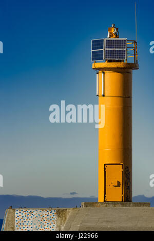 Faro giallo sulla diga frangiflutti a Riga, Europa Foto Stock