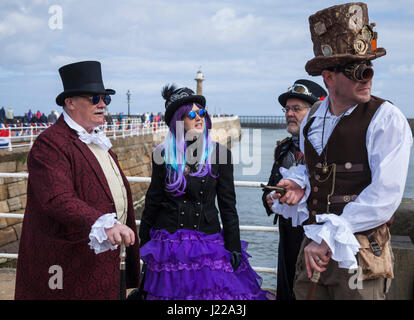 Un gruppo di persone vestite in modo steampunk chat assieme sulla banchina a Whitby al weekend di Goth celebrazioni,North Yorkshire, Inghilterra, Regno Unito Foto Stock