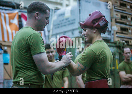 USS SOMERSET, in mare (13 aprile 2017) DEGLI STATI UNITI Marine Corps Sgt. Michael Farrow pone un guanto di boxe su Sgt. Richard Burgia prima di un incontro di pugilato durante un Marine Corps Arti Marziali programma (MCMAP) sessione di formazione a bordo della USS Somerset (LPD 25), Aprile 13. MCMAP insegna fisica e mentale di disciplina, aiutando Marines con xi Marine Expeditionary Unit (MEU) mantenere un combattimento pronto il corpo e la mente. Xi MEU sta attualmente supportando U.S. 7 flotta ha la missione di promuovere e mantenere la stabilità e la sicurezza nella Indo-Asia-regione del Pacifico. (U.S. Marine Corps Foto di Sgt. Xzavior T. McNeal) Foto Stock