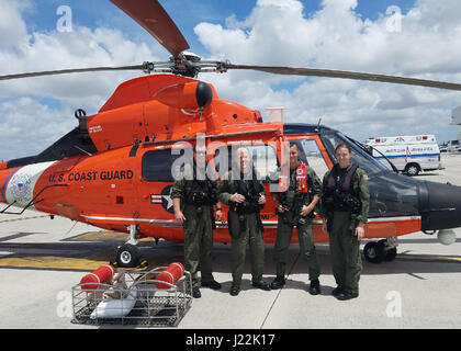 Una guardia costiera Stazione aria Miami MH-65 Delfino elicottero equipaggio in posa per una foto di equipaggio presso la stazione di aria Venerdì, 21 aprile 2017, dopo aver completato un medevac di un 41-anno-vecchio uomo dalla nave da crociera Carnival Magic. L'equipaggio medevacked l uomo a circa 100 miglia a sud-ovest di Key West. Stati Uniti La guardia costiera della foto per gentile concessione della stazione aria Miami Foto Stock