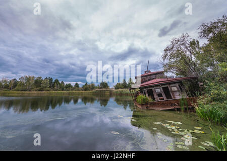 Naufragio barca su un Yanov backwaters nel pripjat città fantasma della centrale nucleare di Cernobyl la zona di alienazione intorno al reattore nucleare disastro, Ucraina Foto Stock