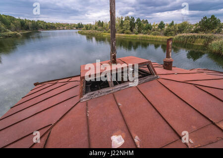 Il tetto del naufragio barca su un Yanov backwaters nel pripjat città fantasma della centrale nucleare di Cernobyl la zona di alienazione in Ucraina Foto Stock