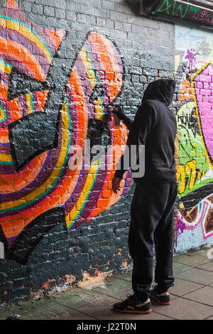 Inghilterra, Londra, Lambeth, Waterloo, Leake Street, Graffiti e parete galleria d'arte, graffiti artista al lavoro Foto Stock