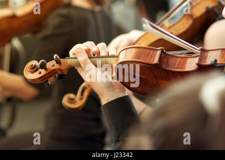 Gli stati di musica classica orchestra che suona il violino su un concerto, irriconoscibile musicista con strumento a corda, il fuoco selettivo Foto Stock
